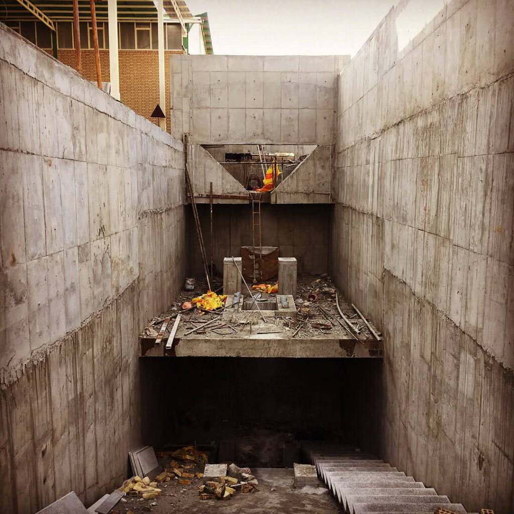 Deep concrete pit with high retaining walls and a partially constructed intermediate slab, prepared for installation of heavy process equipment.