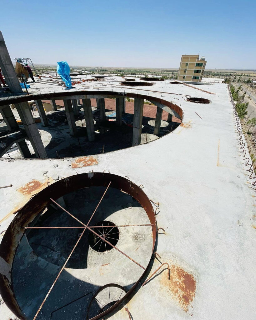A high-angle view of a concrete production floor with multiple circular openings for reactor installation.