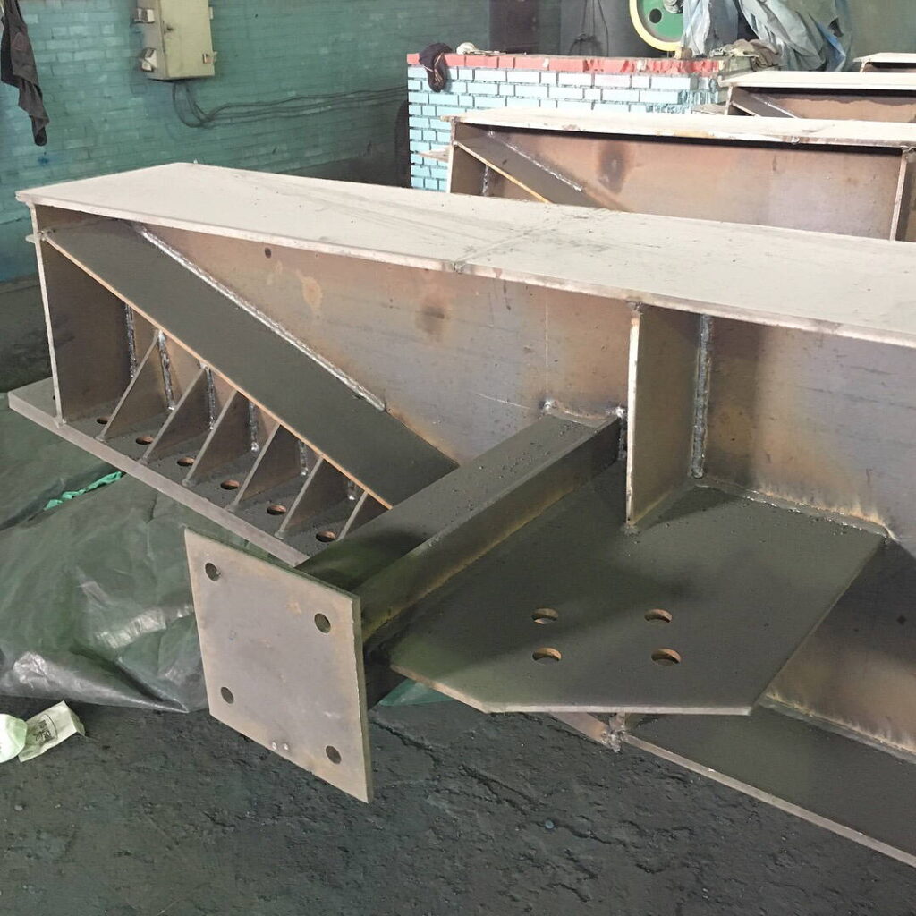 A complex steel joint featuring diagonal bracing and a square connection plate.