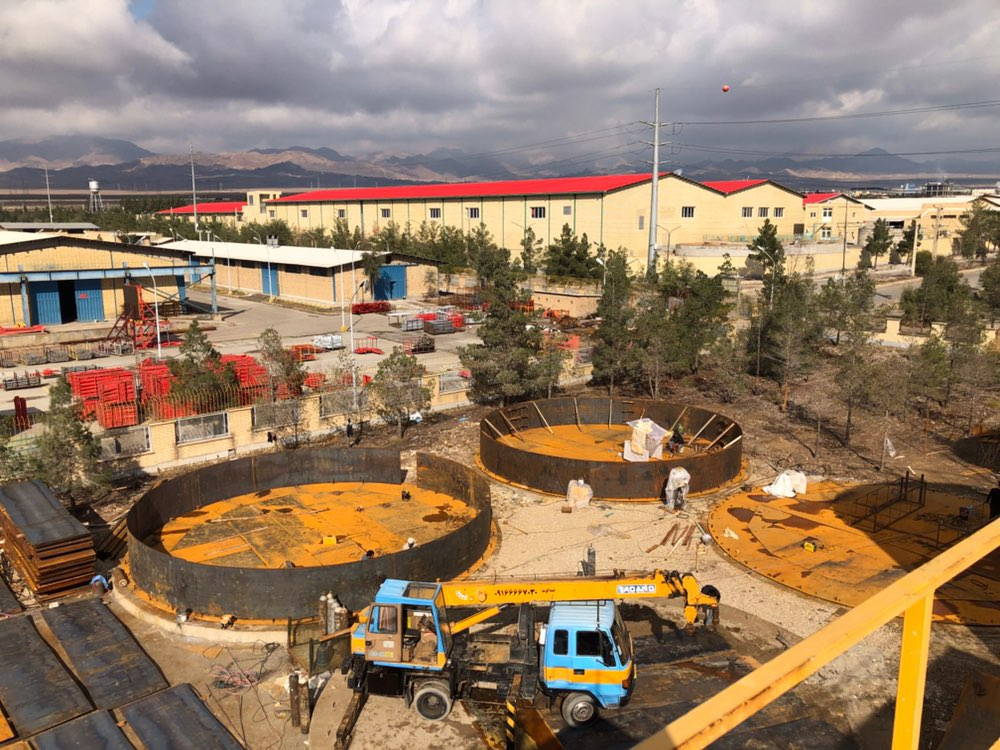 High-angle view of a vast industrial park with green and red roof warehouses.