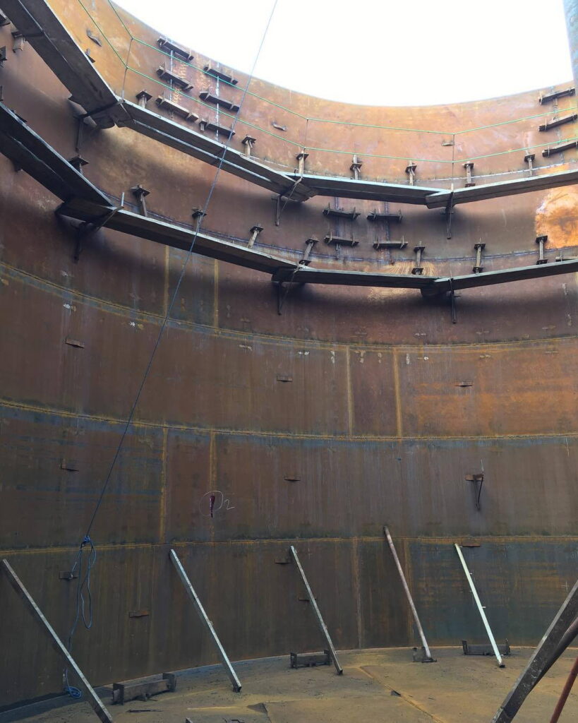 Interior view of a tank shell showing horizontal stiffeners and structural braces.